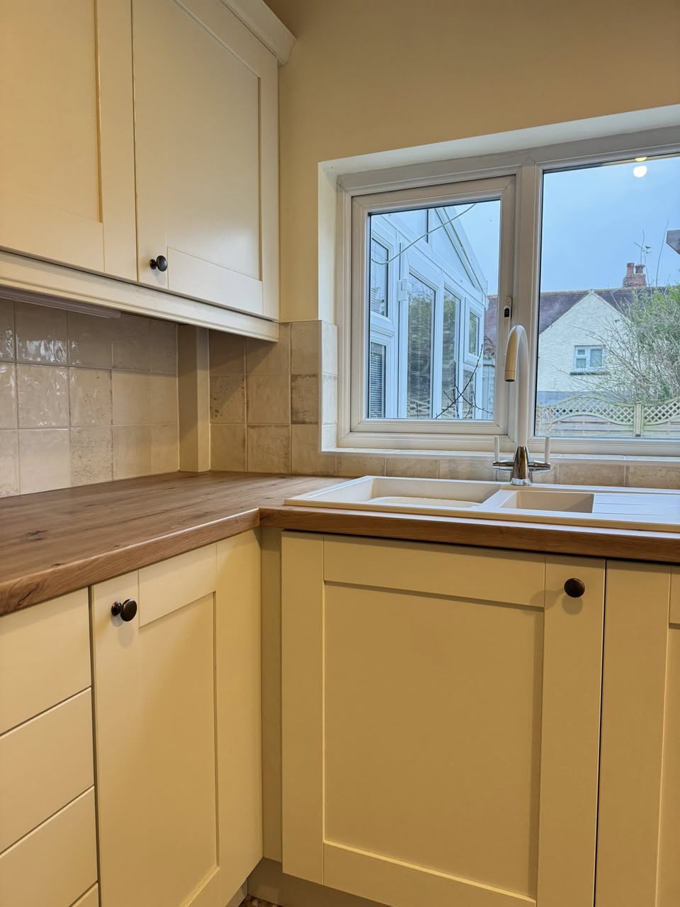 SR Kitchen and bathroom kitchen design and installation Otley with tiled floor, cream kitchen units and wooden worktop