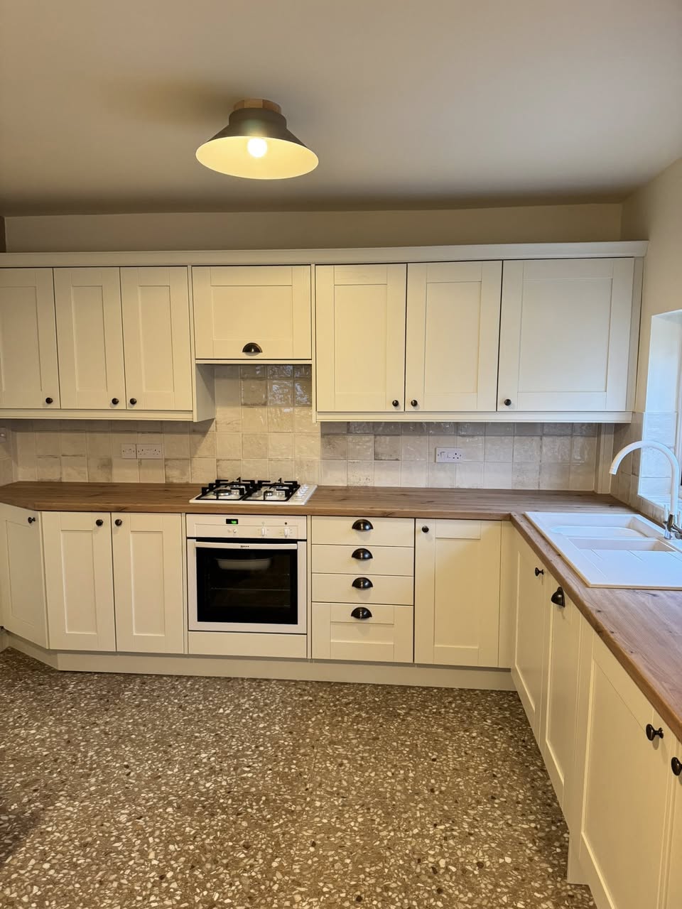 SR Kitchen and bathroom kitchen design and installation Otley with tiled floor, cream kitchen units and wooden worktop