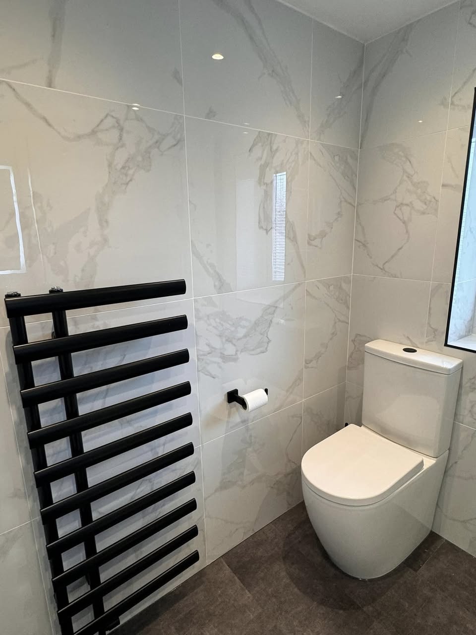 white marble shower room with black taps Otley